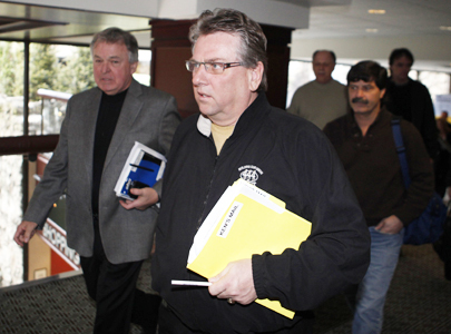 CAW president Ken Lewenza, centre, leaves after speaking to media in Toronto on March 30, 2009. Automakers are in talks over deeper cuts.