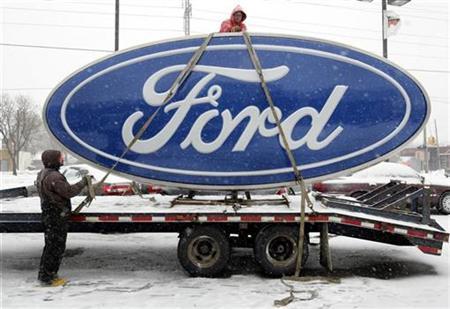 Workers secure a Ford sign onto a truck after it was removed from Al Long Ford auto dealership in Warren, Michigan December 23, 2008. 