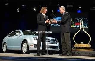 Angus MacKenzie, left, Motor Trend Magazine editor-in-chief, hands the trophy for Car of the Year to Ford Group Vice President Derrick Kuzak. (Bryan Mitchell / Special to The Detroit News)