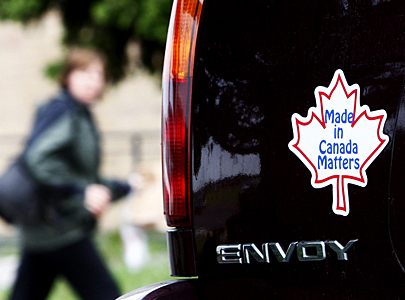 Woman walks by bumper sticker to buy Canadian in Oshawa June 1, 2009 as GM files for bankruptcy protection in New York