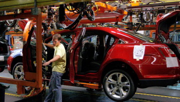 A worker checks on a 2010 Ford Taurus on the assembly line at the Ford plant in Chicago. The plant has been retooled to build the vehicle. Frank Polich/REUTERS