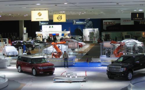 Ford sets up its expanded show stand amid plastic sheets, coiled extension cords and flashing electronic signs.