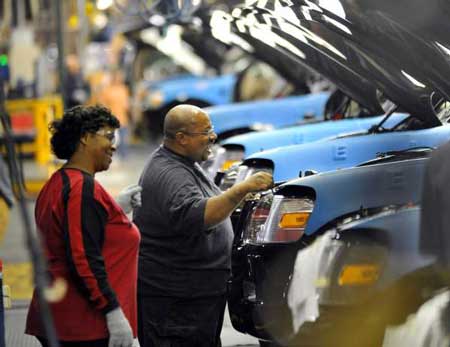Ford employees Monica Stephens, left, and Michael Mathis help a row of 2010 Ford Explorers move through final assembly at a Louisville, Ky., plant Thursday. Ford will add 1,800 workers and invest $600 million in the plant, which will make the next-generation Ford Escape and other vehicles. (Sam VarnHagen / Ford)