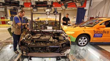 Technicians prepare vehicles for a test crash at the Volvo Safety Centre in Gothenburg, Sweden