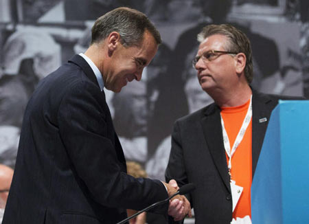 Bank of Canada Governor Mark Carney, left, and CAW National President Ken Lewenza, right, shake hands at the Canadian Automotive Workers' First Constitutional and Collective Bargaining Convention in Toronto on Wednesday. 