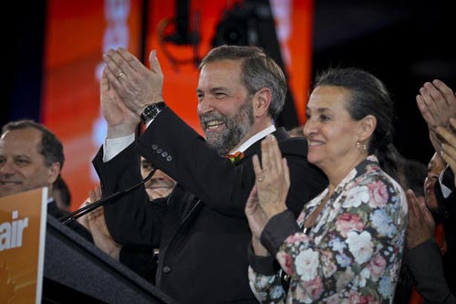 New NDP leader Thomas Mulcair, left, and his wife Catherine Pinhas applaud after Mulcair won the contest to become party leader in Toronto on Saturday.