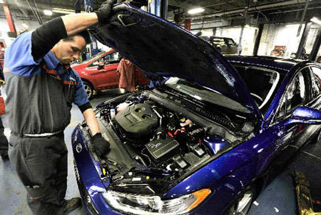Service technician Rich Rushlow examines the popular 2-liter EcoBoost engine in a 2013 Ford Fusion at Village Ford in Dearborn on Friday. (Daniel Mears / The Detroit News)
