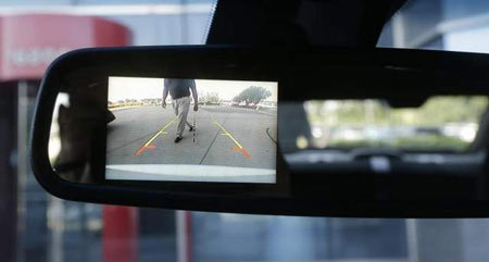 A new surveillance system that displays on the rear view mirror in police cars automatically sounds a chime, locks the doors and rolls up the windows if it detects someone approaching the car from behind. (Carlos Osorio/AP)