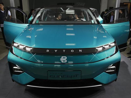 Invited guests and journalists listen to a staff member in the driver's seat of a BYTON electric concept car during a test drive event ahead of the Auto China 2018 automotive exhibition in Beijing, Sunday, April 22, 2018. The biggest global auto show of the year showcases China's ambitions to become a leader in electric cars and the industry's multibillion-dollar scramble to roll out models that appeal to price-conscious but demanding Chinese drivers.