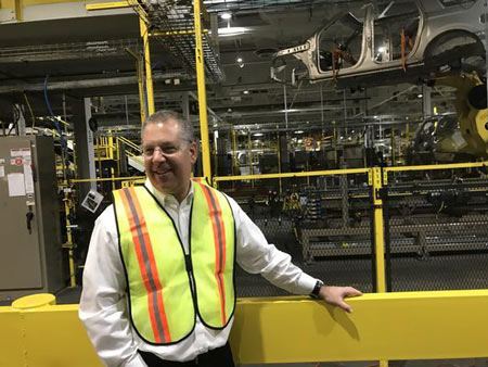 Ford President of Global Operations Joe Hinrichs stands in front of Kong, the robotic arm that places the bodies of Ford Expeditions and Lincoln Navigators on skids to roll down the assembly line in Ford’s Kentucky Truck Plant on Feb. 9, 2018.
