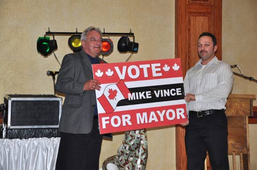 Next step for Mike is the Mayor's office (Holding sign with his son)